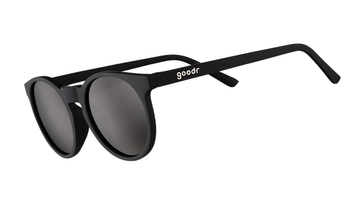 Three-quarter angle view of retro-inspired black round sunglasses with non-reflective black lenses.
